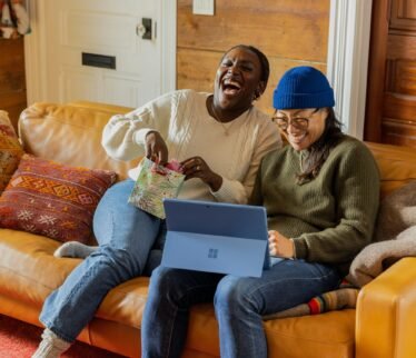 a person sitting on a couch with a laptop