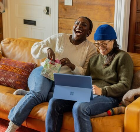 a person sitting on a couch with a laptop